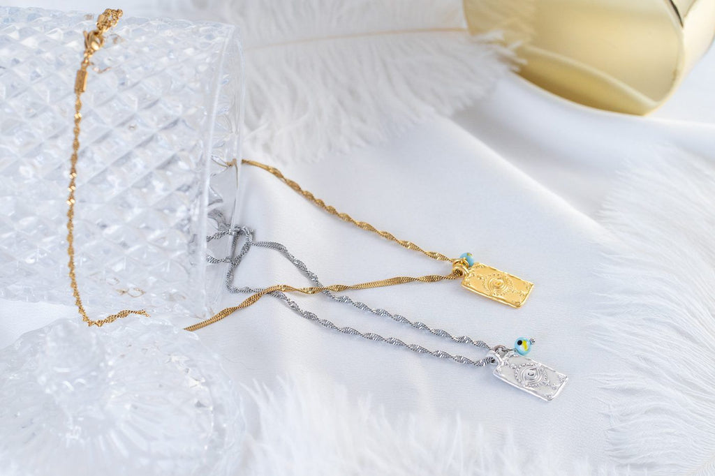 Gold necklace with evil eye protection tag